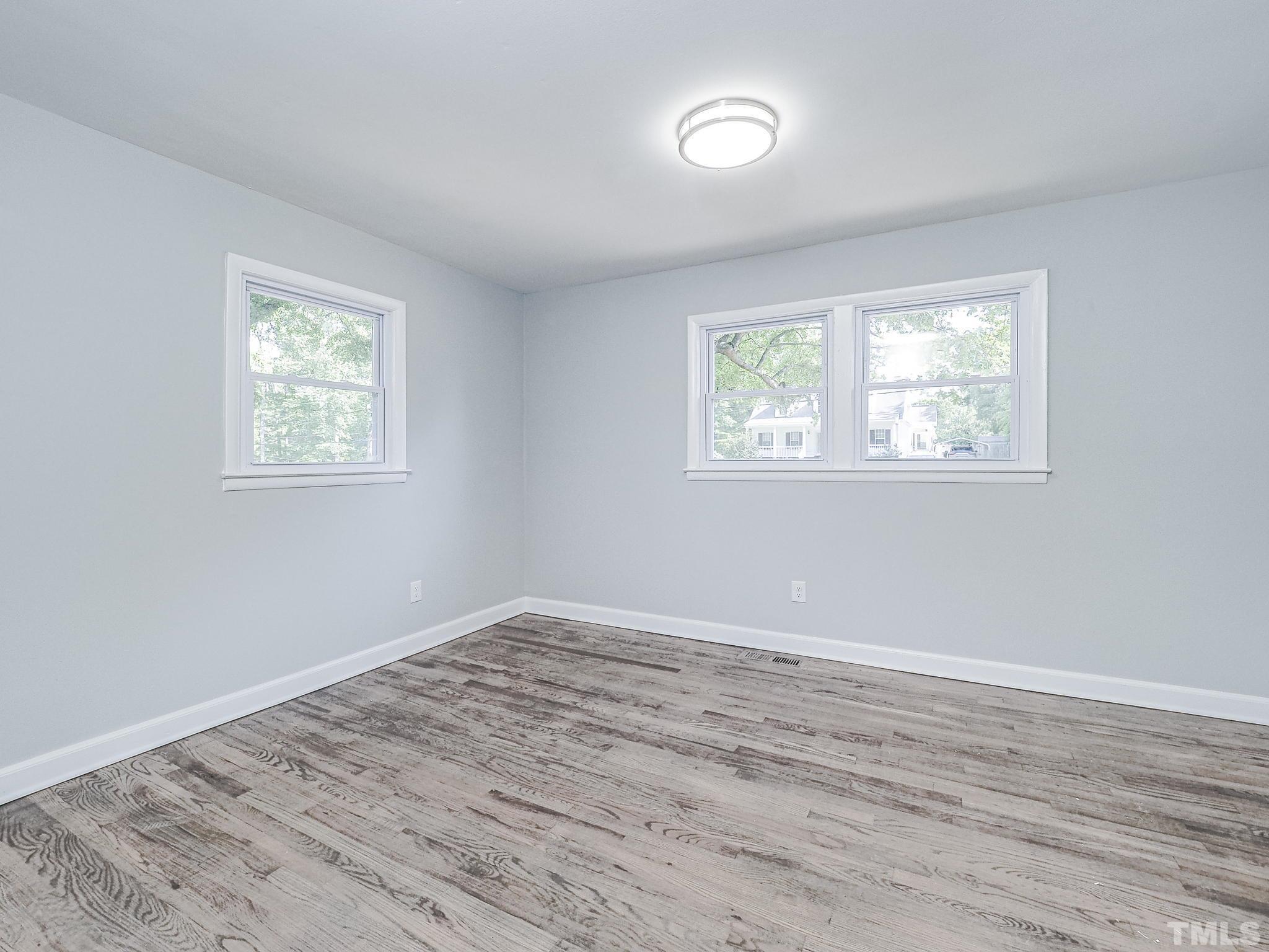 626 Winterlochen Road Raleigh, NC 27603 - Photo 7 of 16 a view of an empty room with wooden floor and a window