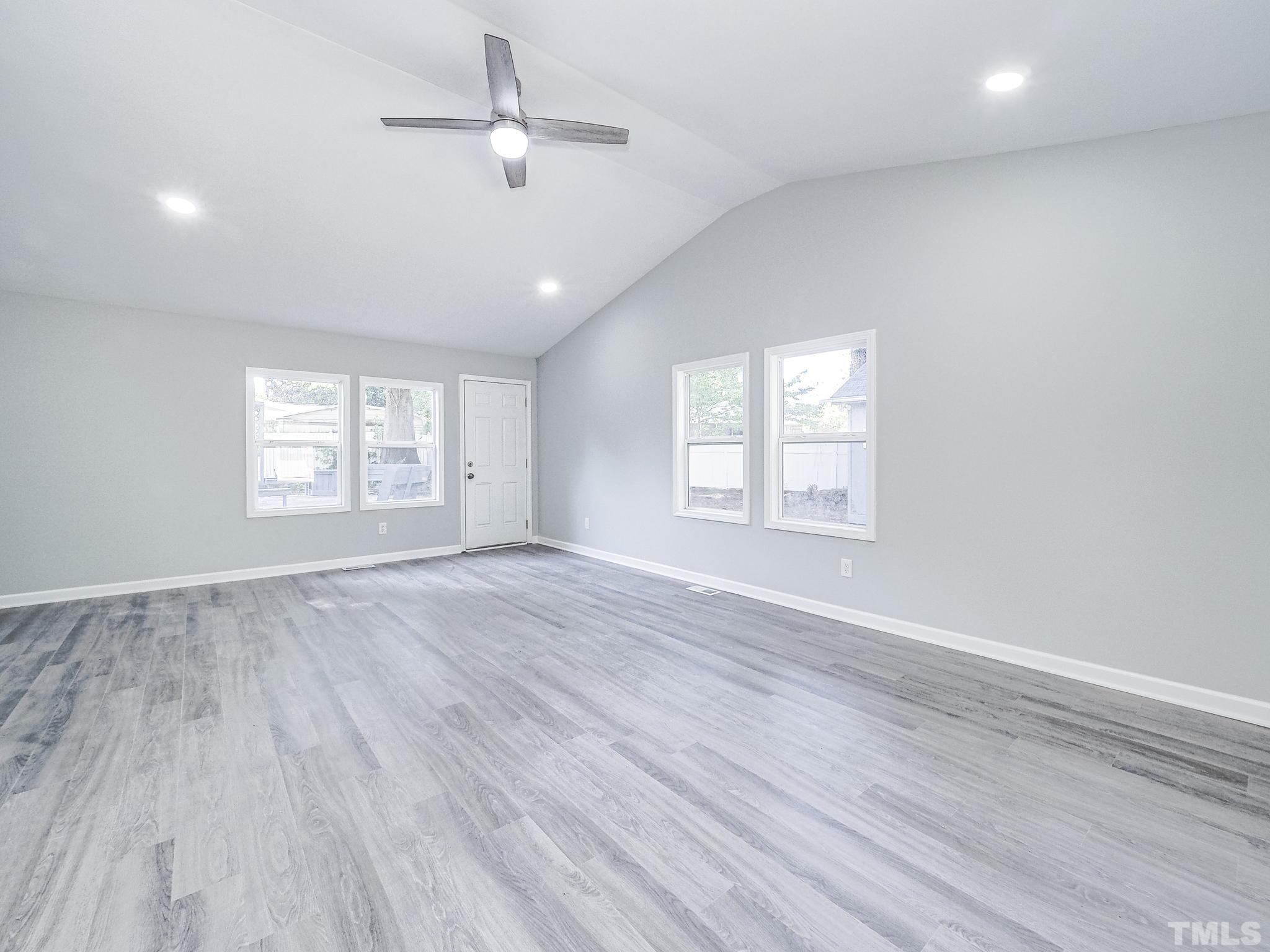 626 Winterlochen Road Raleigh, NC 27603 - Photo 9 of 16 an empty room with wooden floor ceiling fan and windows