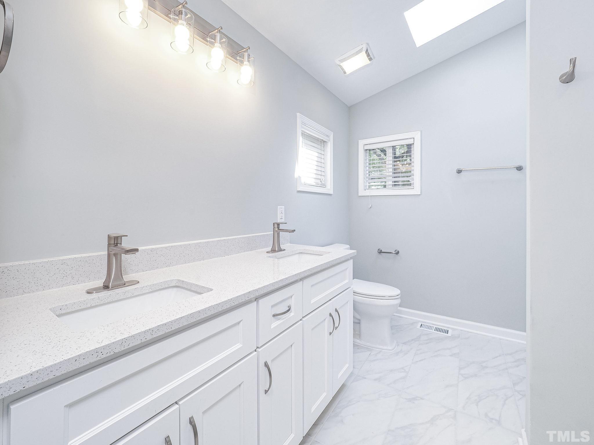 626 Winterlochen Road Raleigh, NC 27603 - Photo 10 of 16 a bathroom with a sink a toilet and a mirror