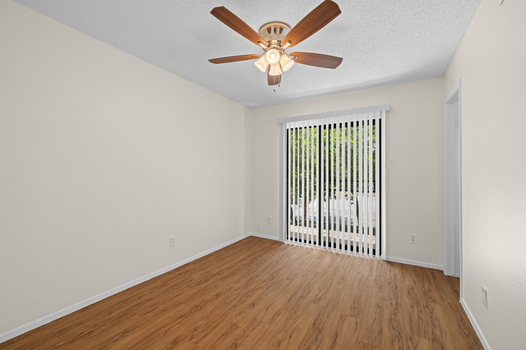 9079 Jollyville Road, Unit 301 Austin, TX 78759 - Photo 21 of 38 #103 A quiet space featuring a ceiling fan, durable wood flooring, and vertical blinds for privacy.