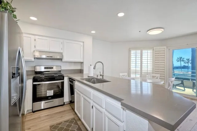 a kitchen with stainless steel appliances granite countertop a sink a stove and a refrigerator