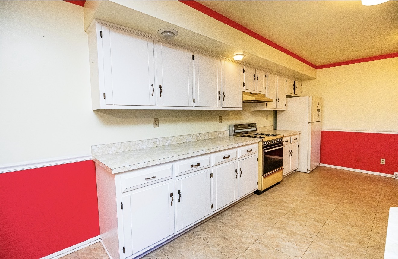 911 Colonade Road Shorewood, IL 60404 - Photo 18 of 36 a kitchen with granite countertop a stove a sink and white cabinets