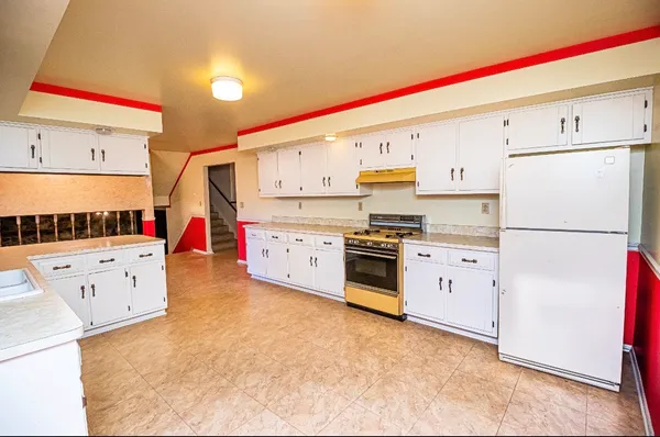 a kitchen with granite countertop a sink and dishwasher a stove with wooden floor