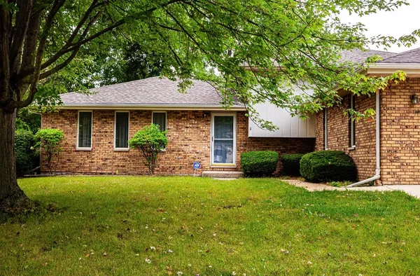 a front view of a house with yard and green space