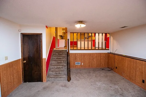 a view of a livingroom with wooden floor and stairs