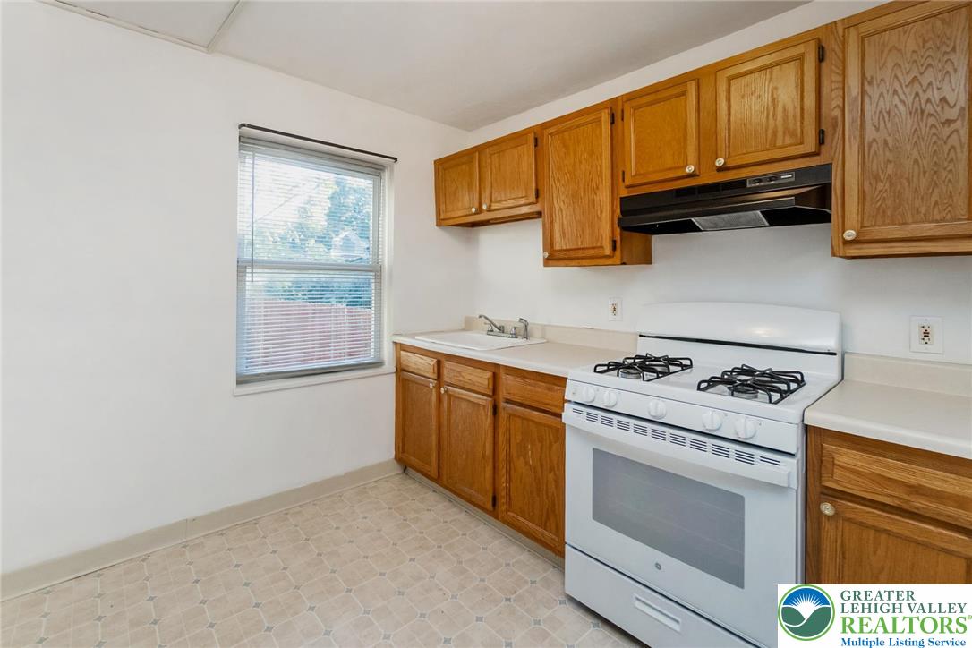 240 Palmer Street Easton, PA 18042 - Photo 12 of 37 a kitchen with wooden cabinets stove top oven and sink