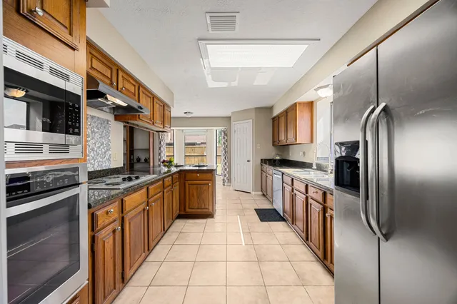 a kitchen with stainless steel appliances granite countertop a refrigerator and a stove