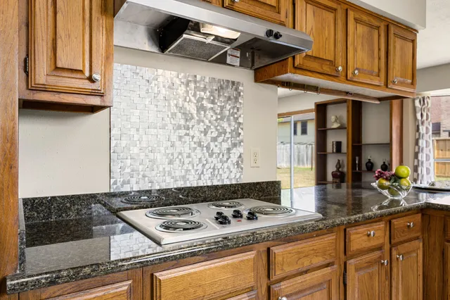 a kitchen with granite countertop a stove and a sink