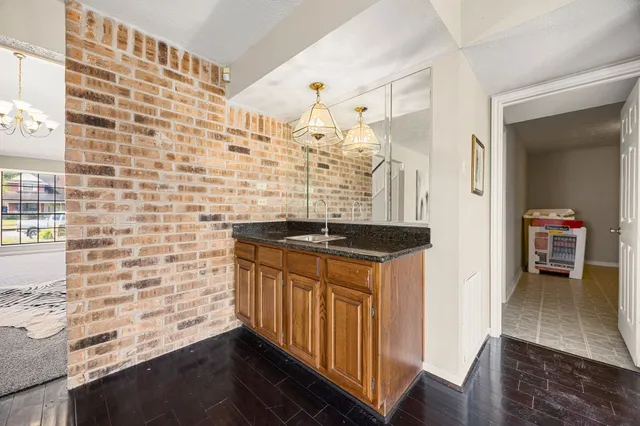 a view of a hallway with wooden floor and a bathroom