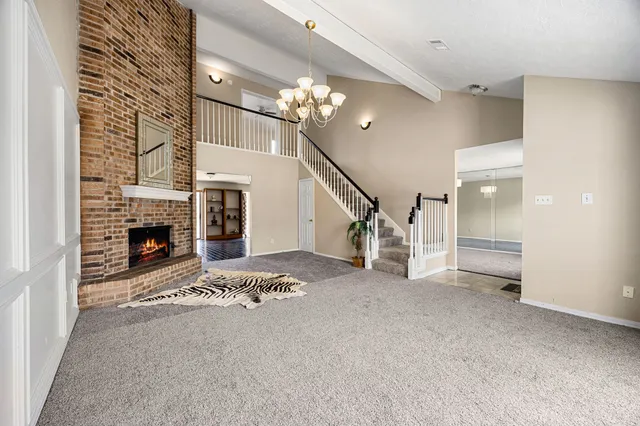 a view of an empty room with fireplace and a window