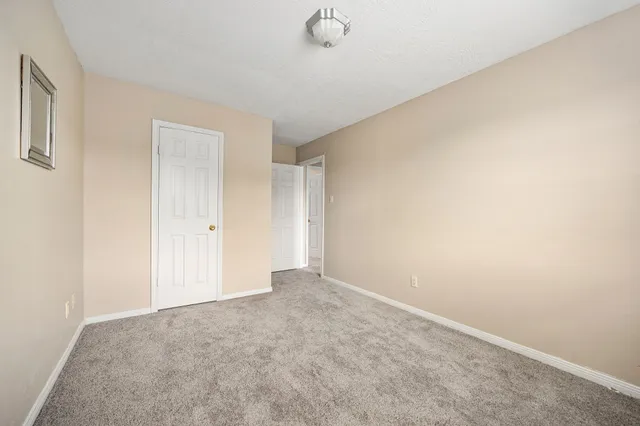 an empty room with a window and a ceiling fan