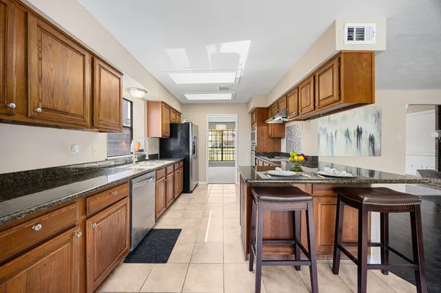 a kitchen with granite countertop stainless steel appliances and wooden cabinets