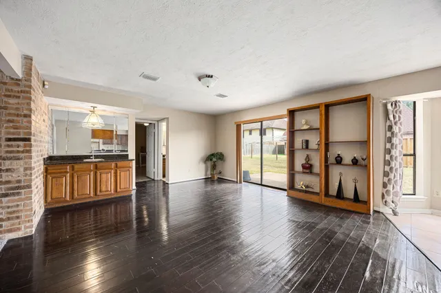 a view of an empty room with window and wooden floor