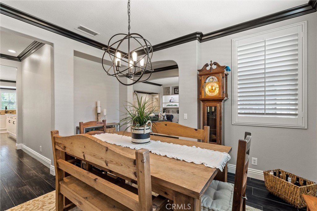 2440 Highwood Road Orange, CA 92867 - Photo 14 of 53 a dining room with wooden floor a chandelier a wooden table and chairs