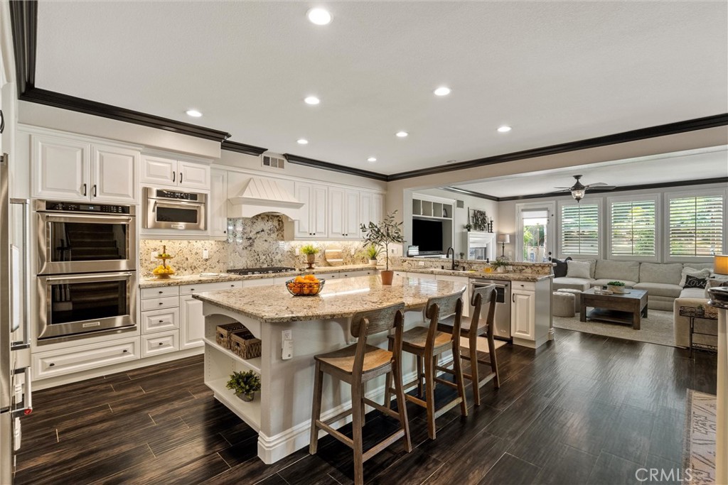 2440 Highwood Road Orange, CA 92867 - Photo 17 of 53 a kitchen with stainless steel appliances granite countertop a stove top oven a sink a dining table and chairs with wooden floor