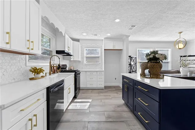 a kitchen with kitchen island granite countertop a sink counter top space appliances and cabinets