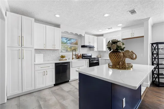 a kitchen with kitchen island white cabinets and appliances