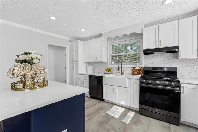 a kitchen with a stove a sink and a window