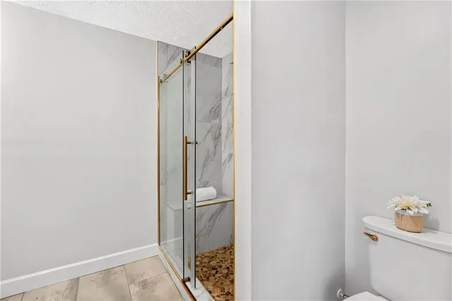 a bathroom with a shower toilet and sink