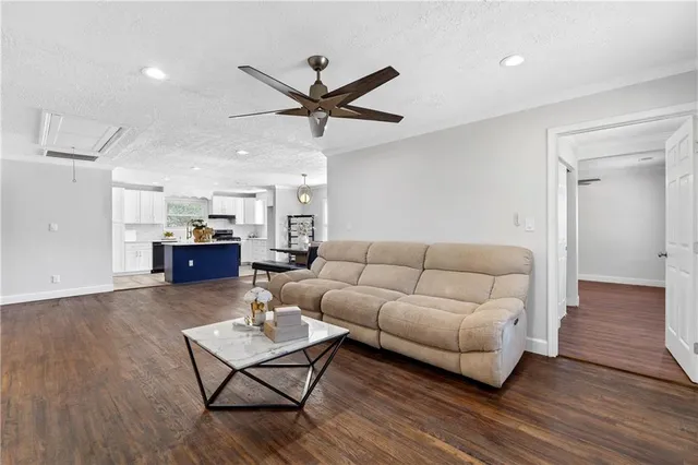 a living room with furniture and a wooden floor