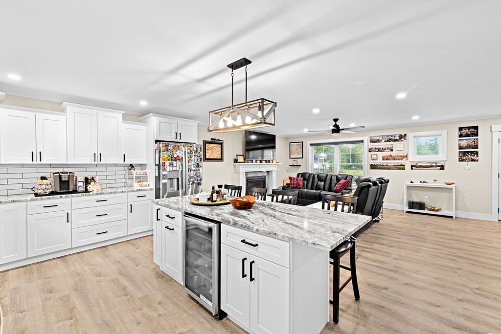 8 Big River Road Coventry, RI 02816 - Photo 14 of 42 a view of a kitchen counter space with stainless steel appliances granite countertop a stove top oven a dining table and chairs with wooden floor