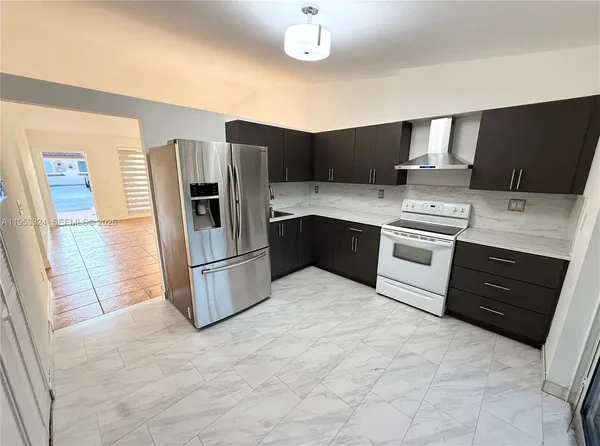 a kitchen with stainless steel appliances granite countertop a refrigerator stove and oven