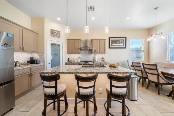 a kitchen with granite countertop chairs and white appliances