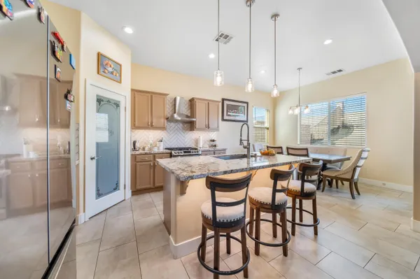 a large kitchen with a table and chairs