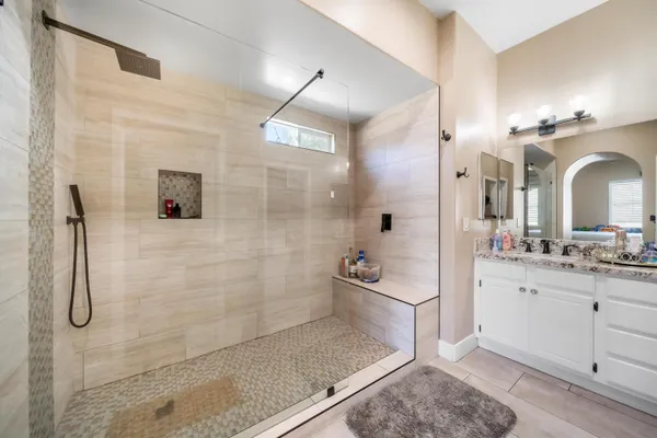 a bathroom with a granite countertop sink a shower and mirror