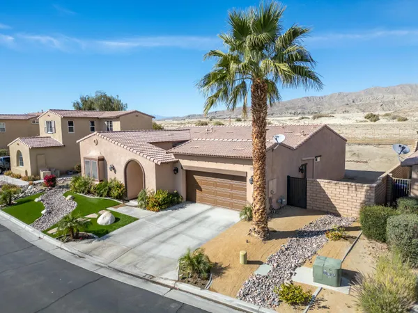 a front view of a house with garden space and sitting area