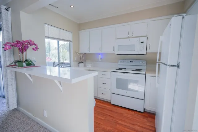 a kitchen with white cabinets and sink