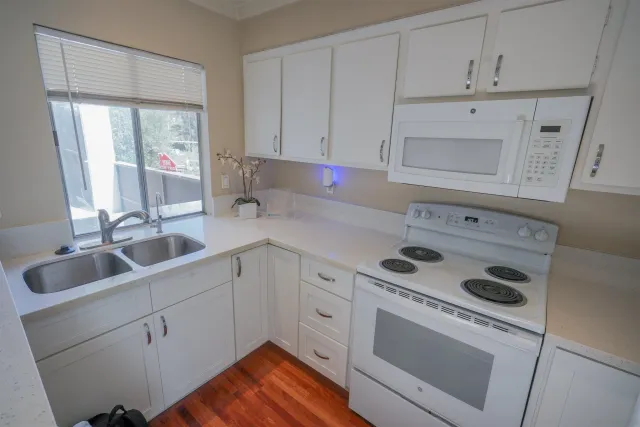 a kitchen with white cabinets sink and white appliances
