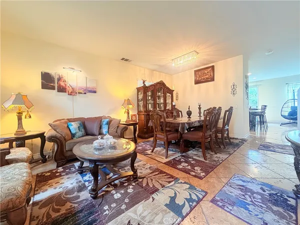 a living room with a coffee table and a dining table with garden view