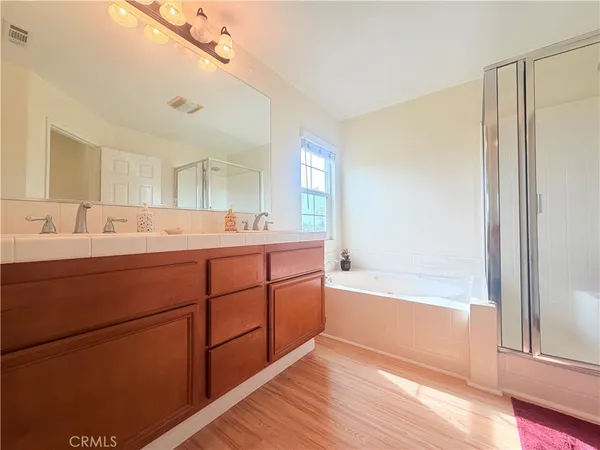 a bathroom with a double vanity sink a mirror and a bathtub
