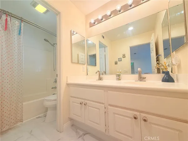 a bathroom with a double vanity sink toilet and shower