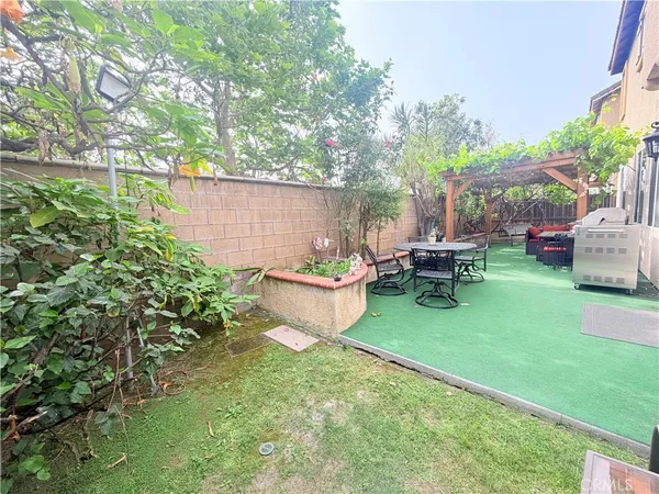 a view of a patio with table and chairs potted plants and a large tree
