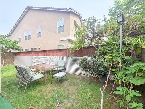 a view of a chair and table in backyard of the house
