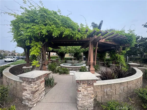 a view of a patio with table and chairs potted plants and large tree