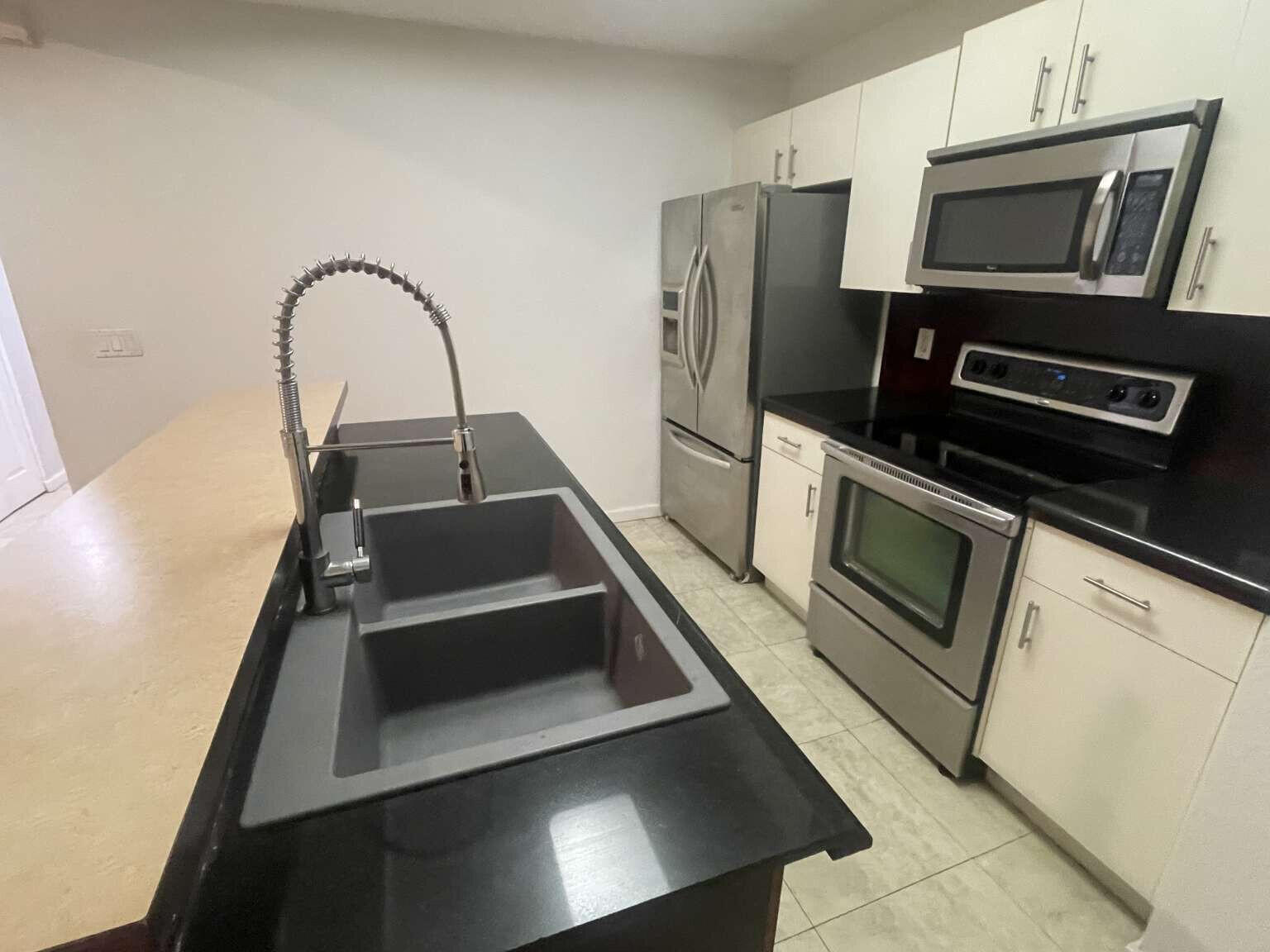 2944 Hidden Hills Road, Unit 1604 West Palm Beach, FL 33411 - Photo 4 of 11 a kitchen with appliances and a microwave