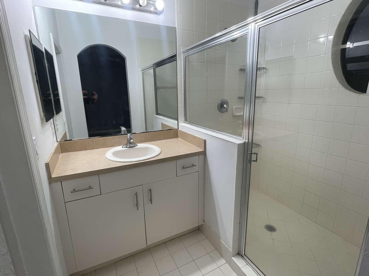 2944 Hidden Hills Road, Unit 1604 West Palm Beach, FL 33411 - Photo 7 of 11 a bathroom with a sink and a mirror