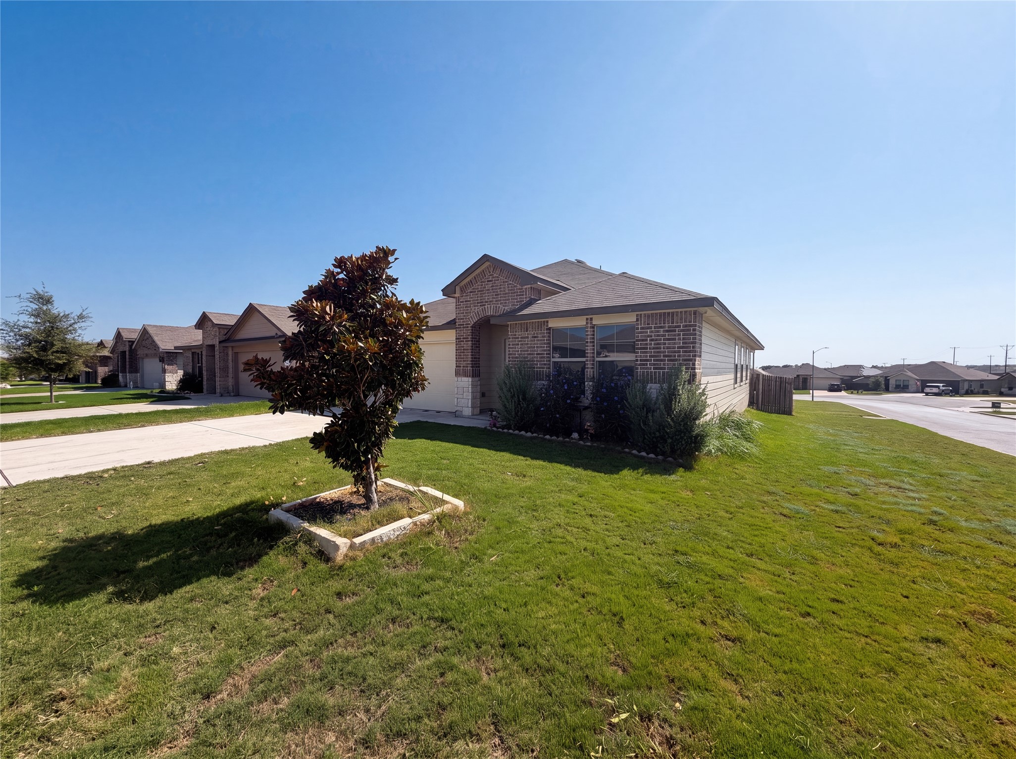 233 Atwood Loop Jarrell, TX 76537 - Photo 14 of 15 Brick detailing and a neat lawn frame the exterior of this single-family residence.