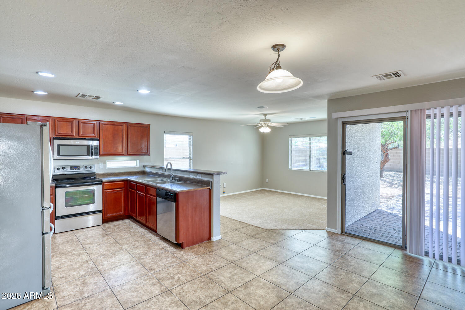 21619 West Durango Street Buckeye, AZ 85326 - Photo 11 of 30 a large kitchen with stainless steel appliances granite countertop a stove and a refrigerator