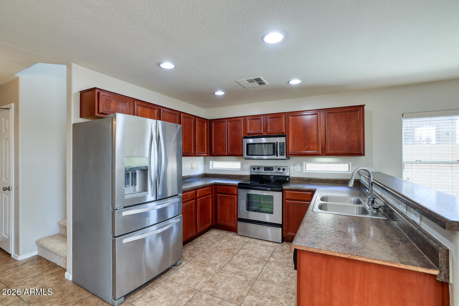 21619 West Durango Street Buckeye, AZ 85326 - Photo 12 of 30 a kitchen with stainless steel appliances granite countertop a refrigerator a stove top oven a sink and dishwasher