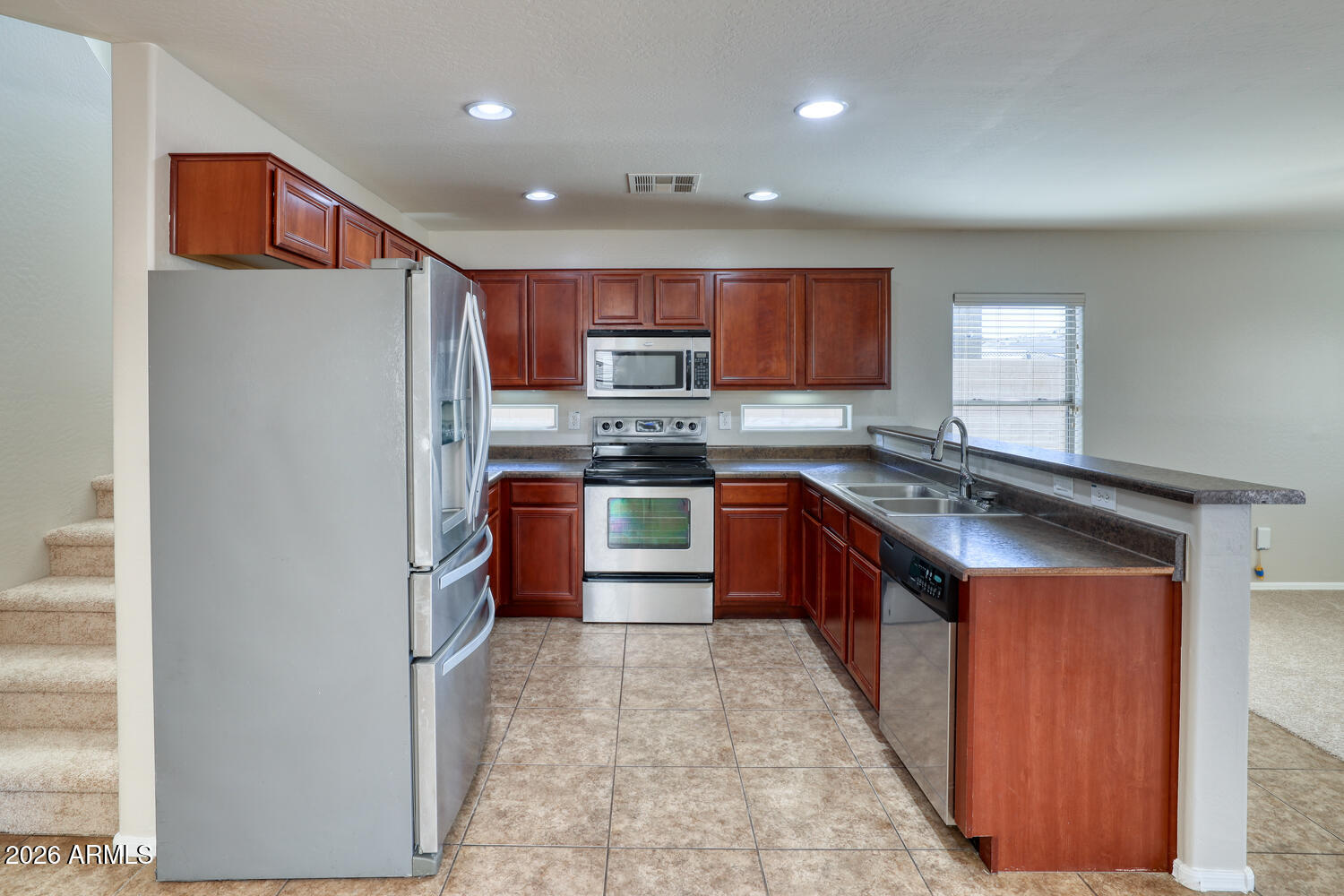 21619 West Durango Street Buckeye, AZ 85326 - Photo 13 of 30 a large kitchen with stainless steel appliances granite countertop a stove top oven a sink and a refrigerator