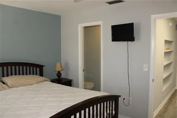 a bedroom with a bed and a flat screen tv