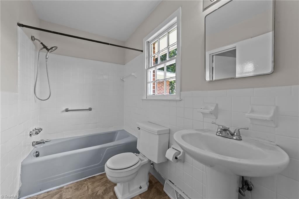 2507 Fontaine Road Greensboro, NC 27407 - Photo 19 of 34 Attached primary bathroom with single bowl vanity mirro and shower & tub combo.