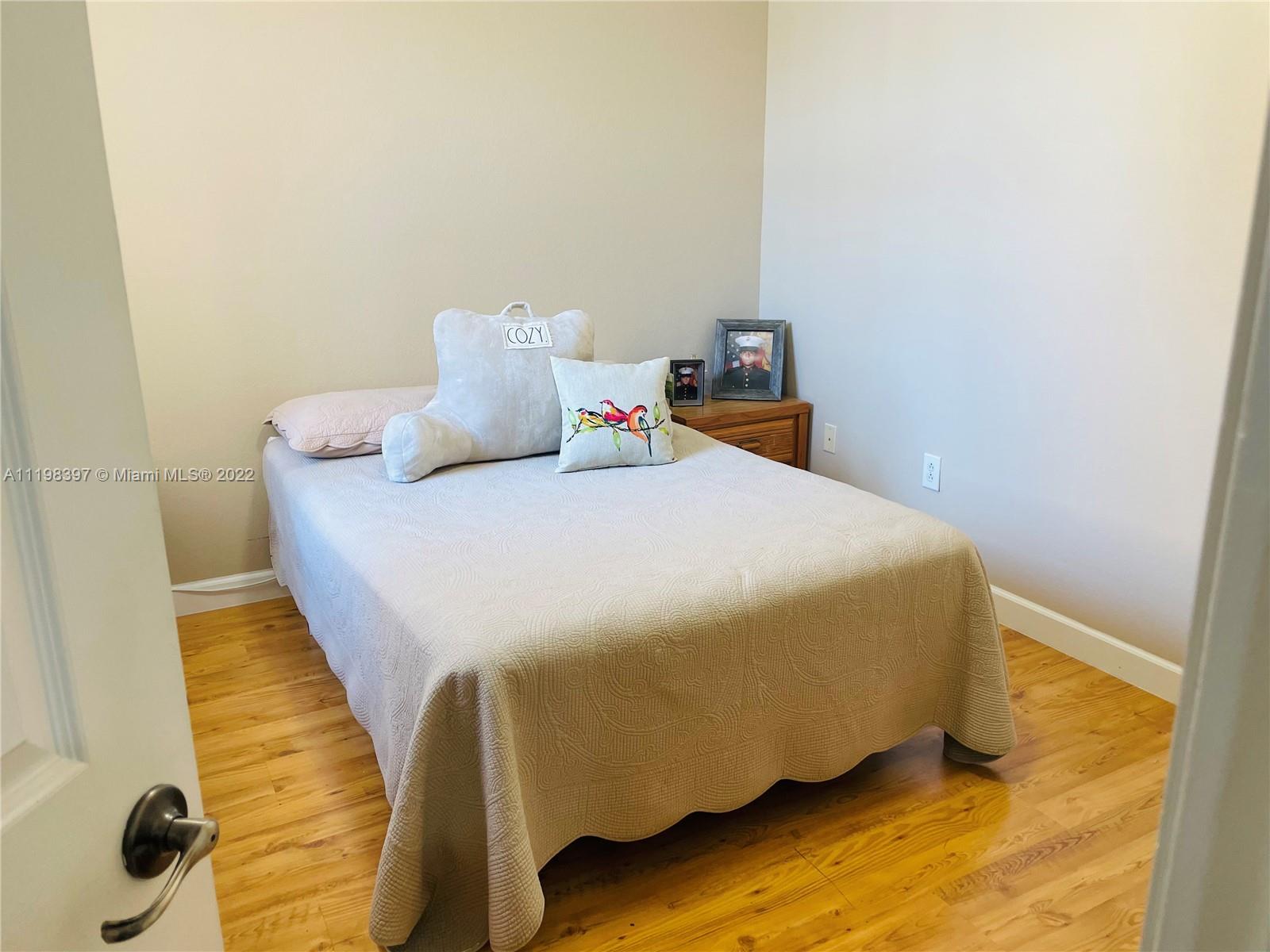 10975 Southwest 246th Street Homestead, FL 33032 - Photo 15 of 20 a bedroom with a bed and wooden floor