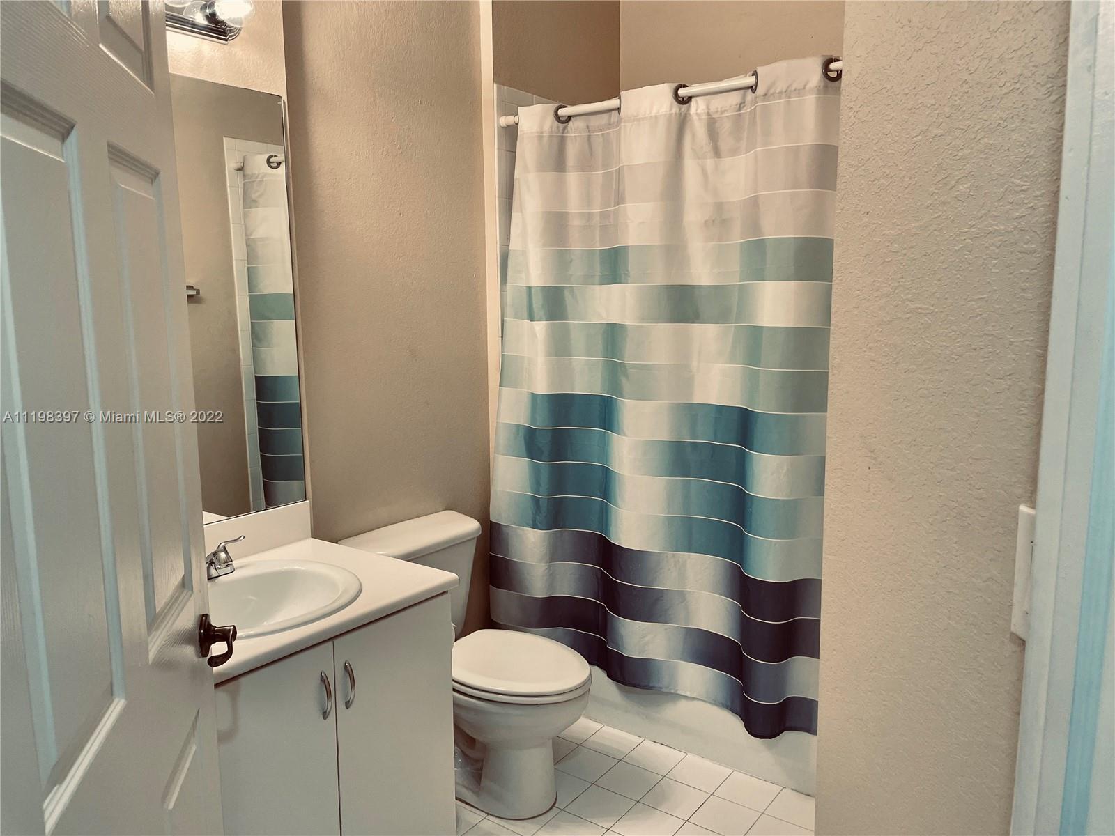 10975 Southwest 246th Street Homestead, FL 33032 - Photo 17 of 20 a bathroom with a sink a toilet a shower and a mirror