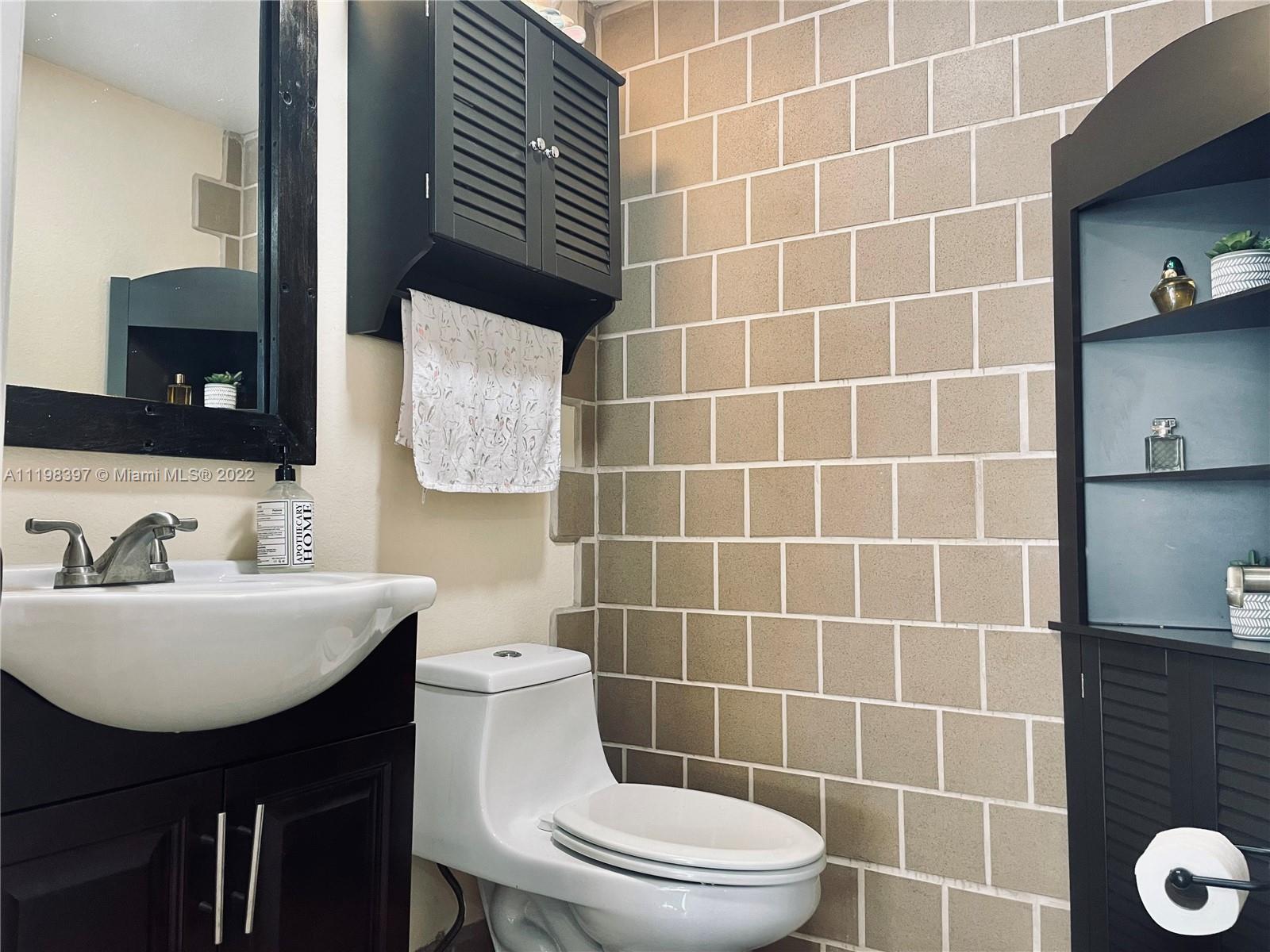 10975 Southwest 246th Street Homestead, FL 33032 - Photo 19 of 20 a bathroom with a sink a toilet and mirror