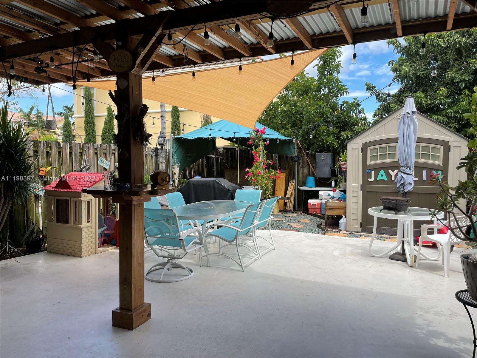 10975 Southwest 246th Street Homestead, FL 33032 - Photo 4 of 20 a view of the patio with a table and chairs under an umbrella